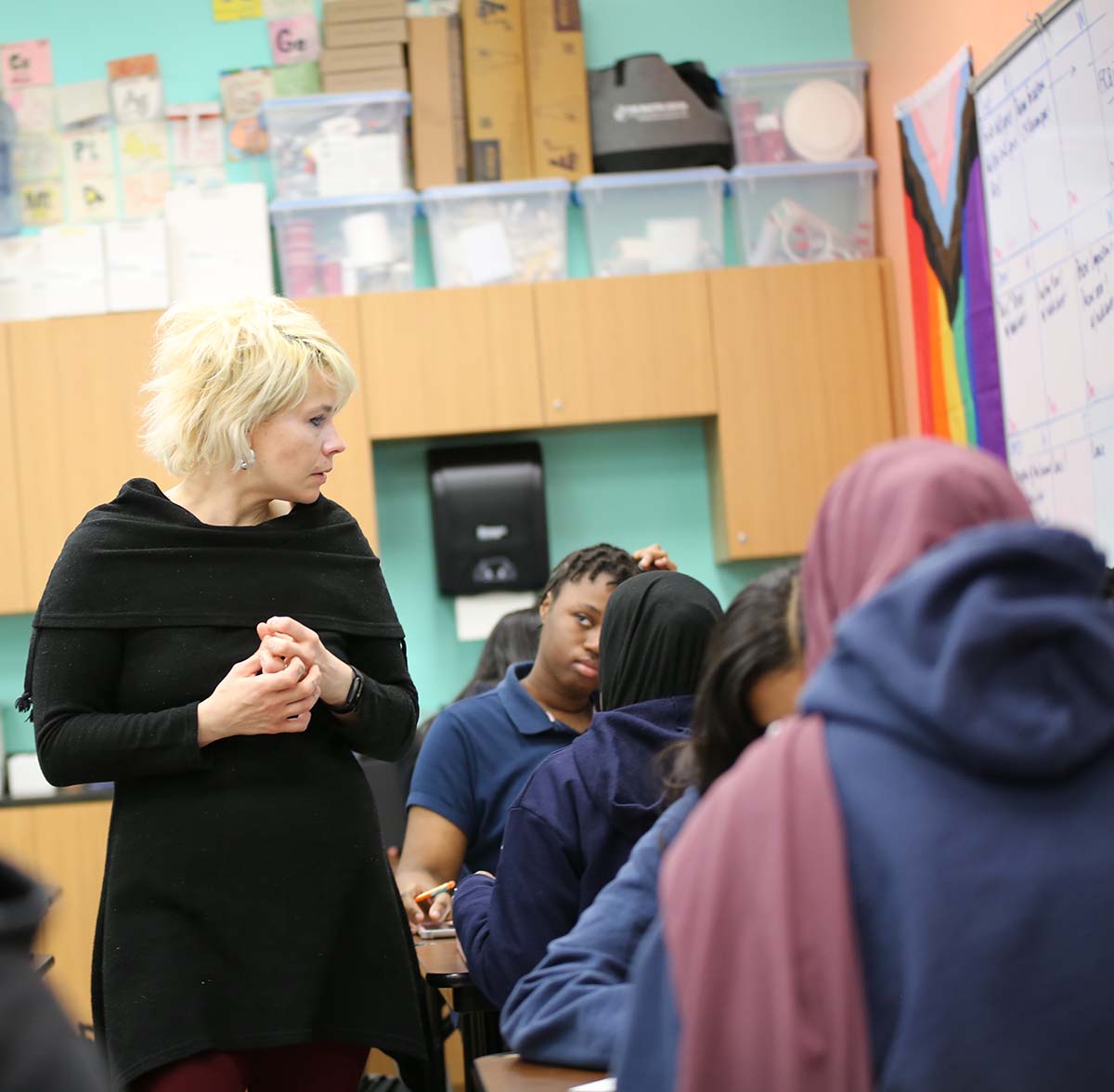 CMSA Teacher and student interacting at a classroom desk