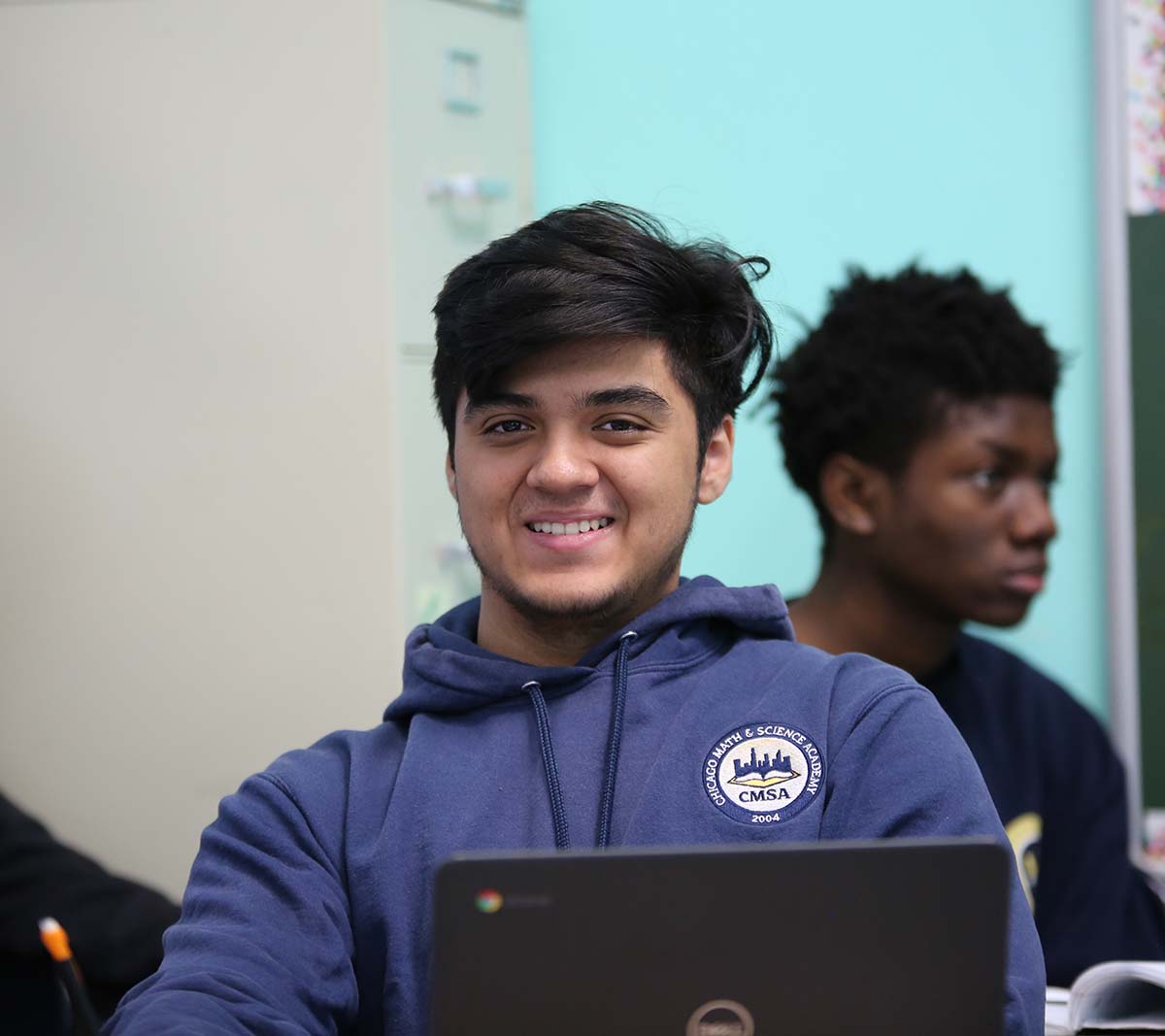 Student working on a notebook in a classroom.